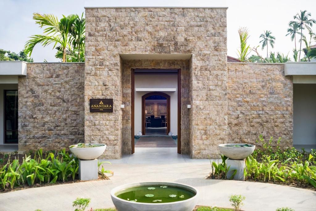 The stone-clad entrance with the Anantara name beside the door and a lotus bowl in front